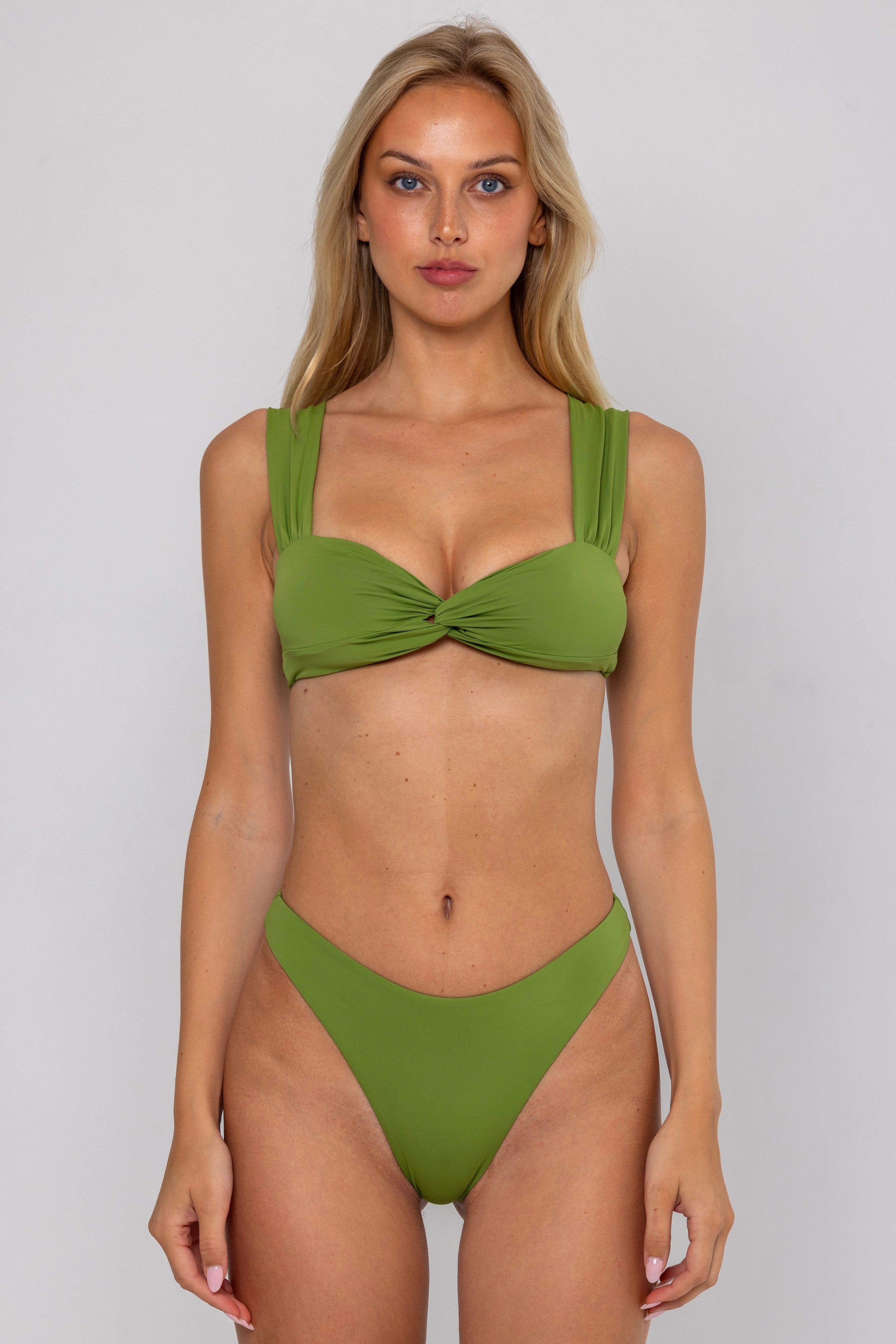 Woman wearing a green bikini against a plain background